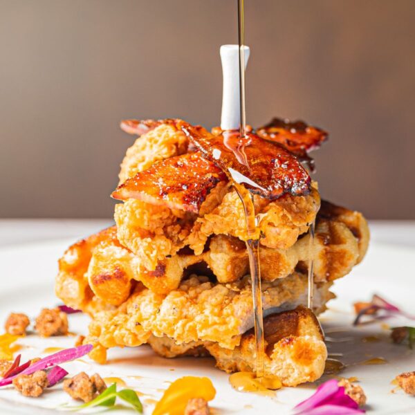 chicken and waffles with syrup being poured